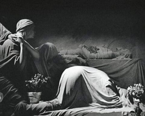 Escultura monocromática evocativa com figuras cobertas por véus fúnebres — estética associada ao imaginário visual de Joy Division.