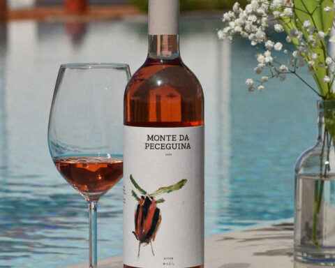Garrafa de vinho rosé Monte da Peceguina com copo servido junto a uma piscina.