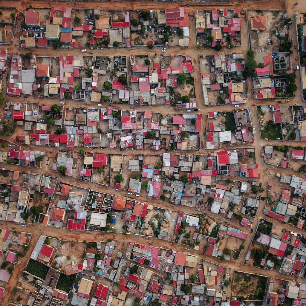 Vista aérea de um musseque em Luanda com casas densamente distribuídas.