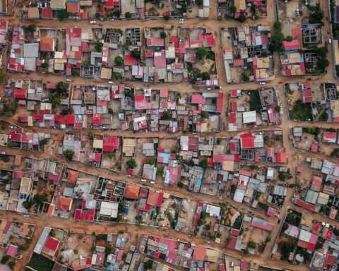 Vista aérea de um musseque em Luanda com casas densamente distribuídas.