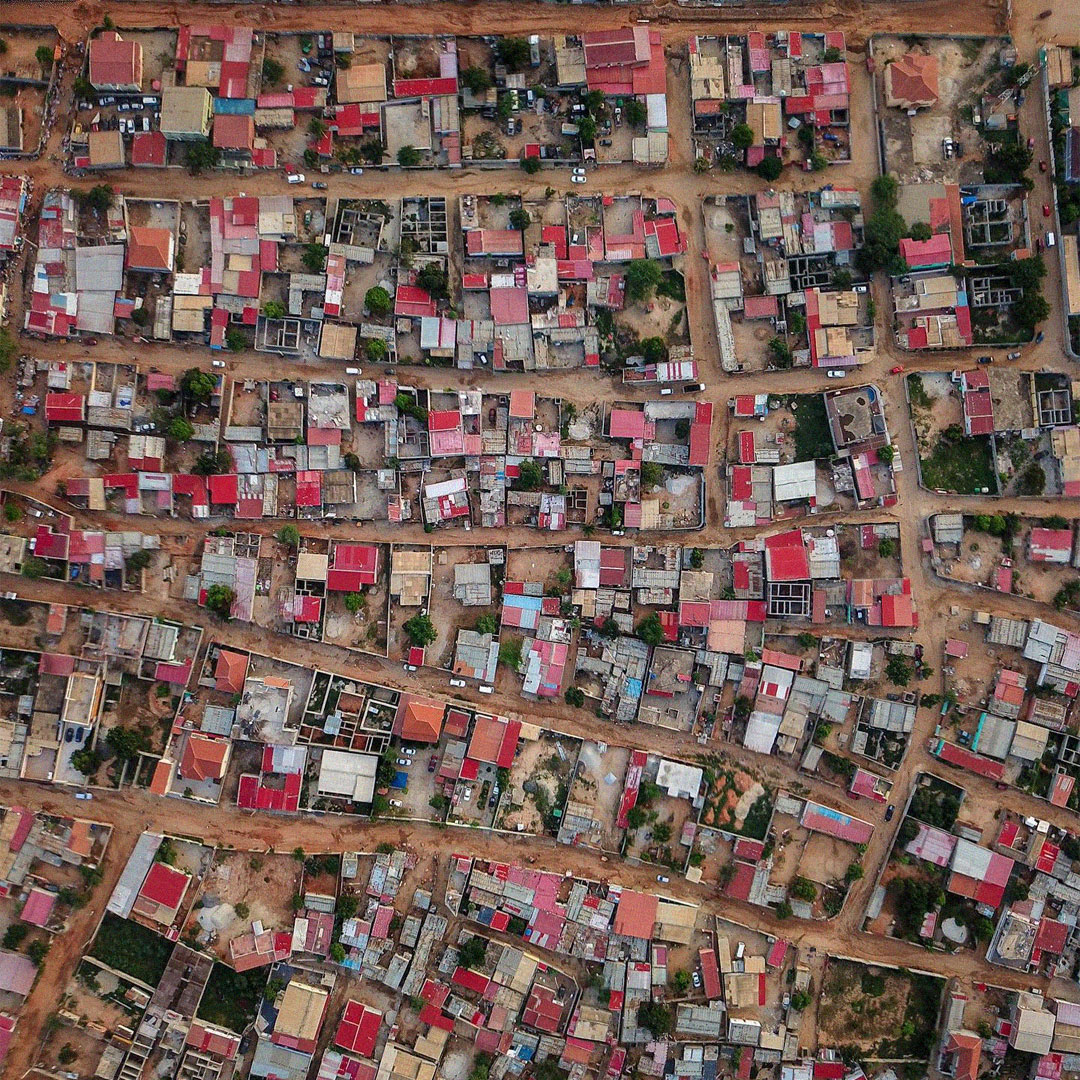 Vista aérea de um musseque em Luanda com casas densamente distribuídas.