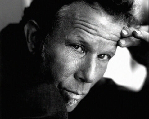 Retrato a preto e branco de Tom Waits com expressão intensa.