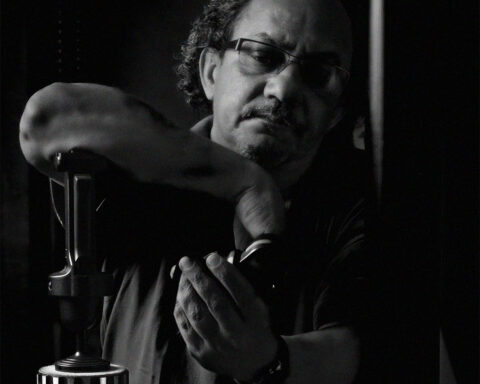 Fotógrafo a trabalhar com equipamento de estúdio em retrato a preto e branco