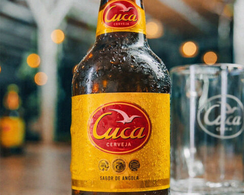 Garrafa de cerveja Cuca com rótulo visível e copo ao lado.