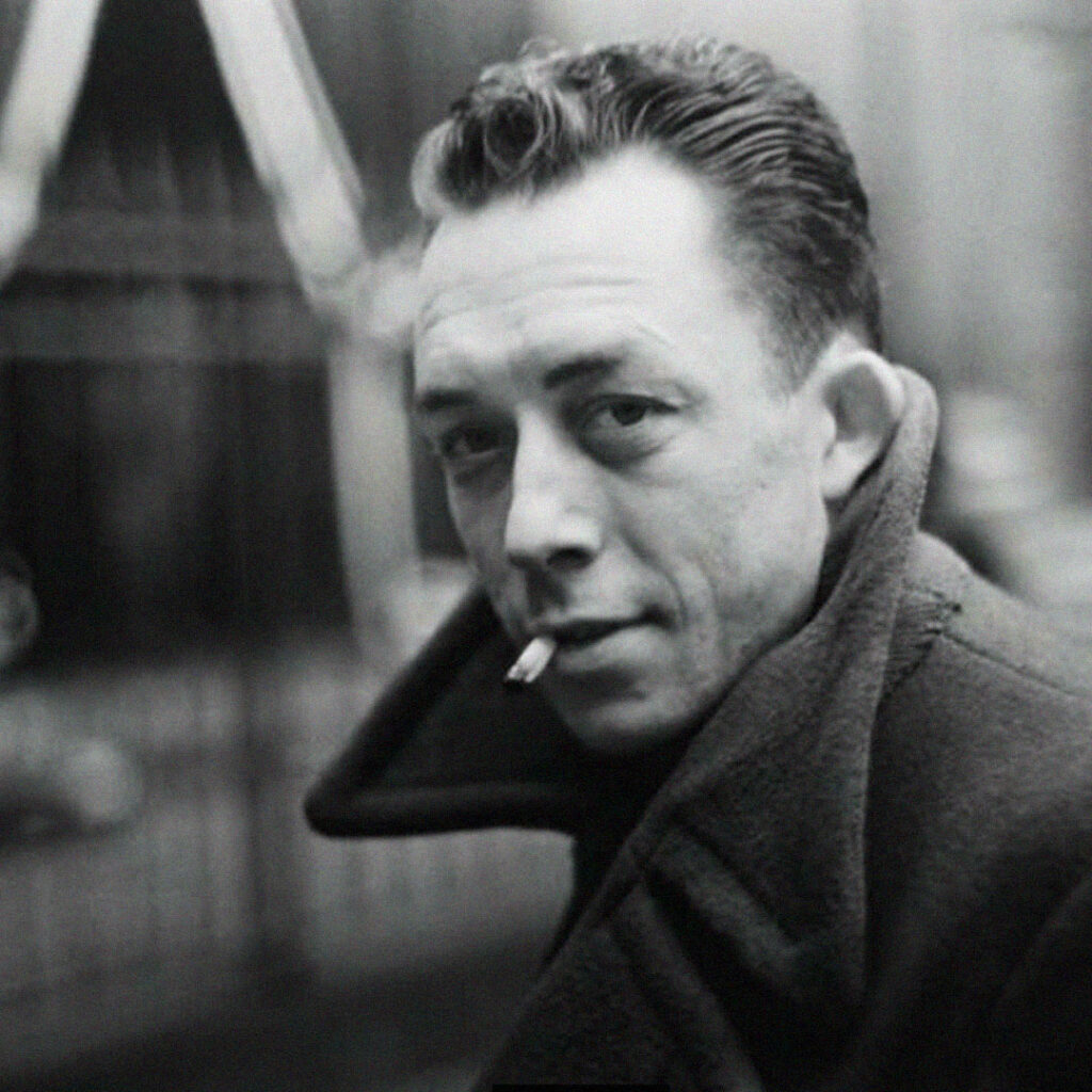 Retrato a preto e branco de homem com cigarro e sobretudo.