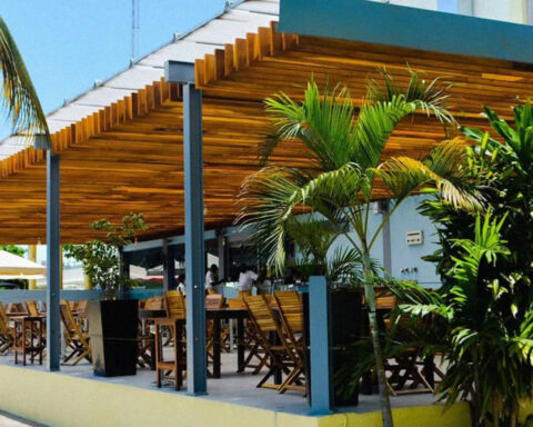 Esplanada do restaurante Convés em Luanda com cobertura de madeira, mesas ao ar livre e vegetação tropical.